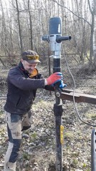 Делаю подкоп лопатой, ставлю сваю, одеваю сваекрут, включаю. Держу визуально ровно. Свая закручивается.